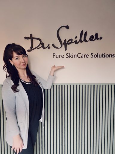 Frau zeigt auf das Logo von Dr. Spiller Pure SkinCare Solutions.